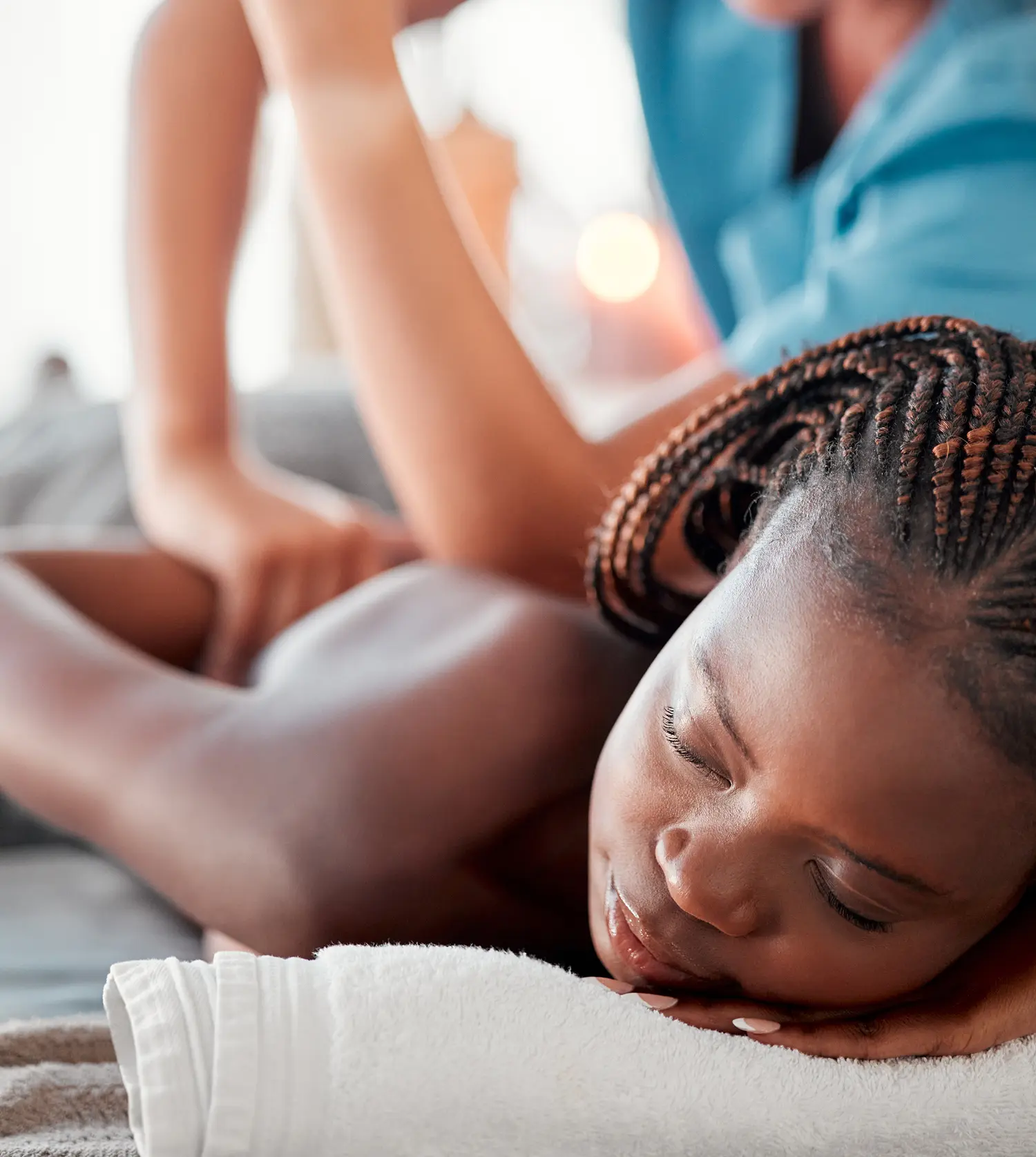 African woman enjoying a relaxing back and shoulder massage during her Traveller's Jetlag Rejuvenating Therapy experience at Pause Spa