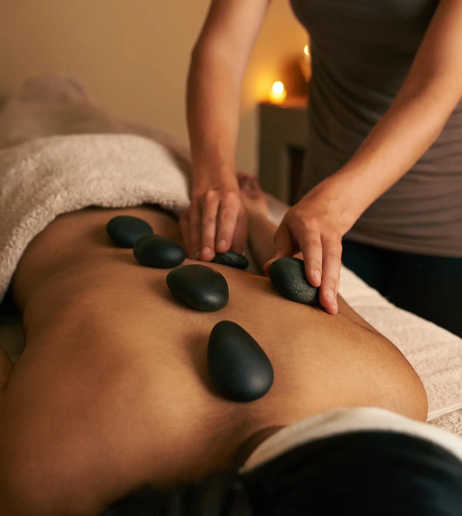 Woman enjoying a hot stone massage during her Hot Stone Full-Body Massage experience at Pause Spa