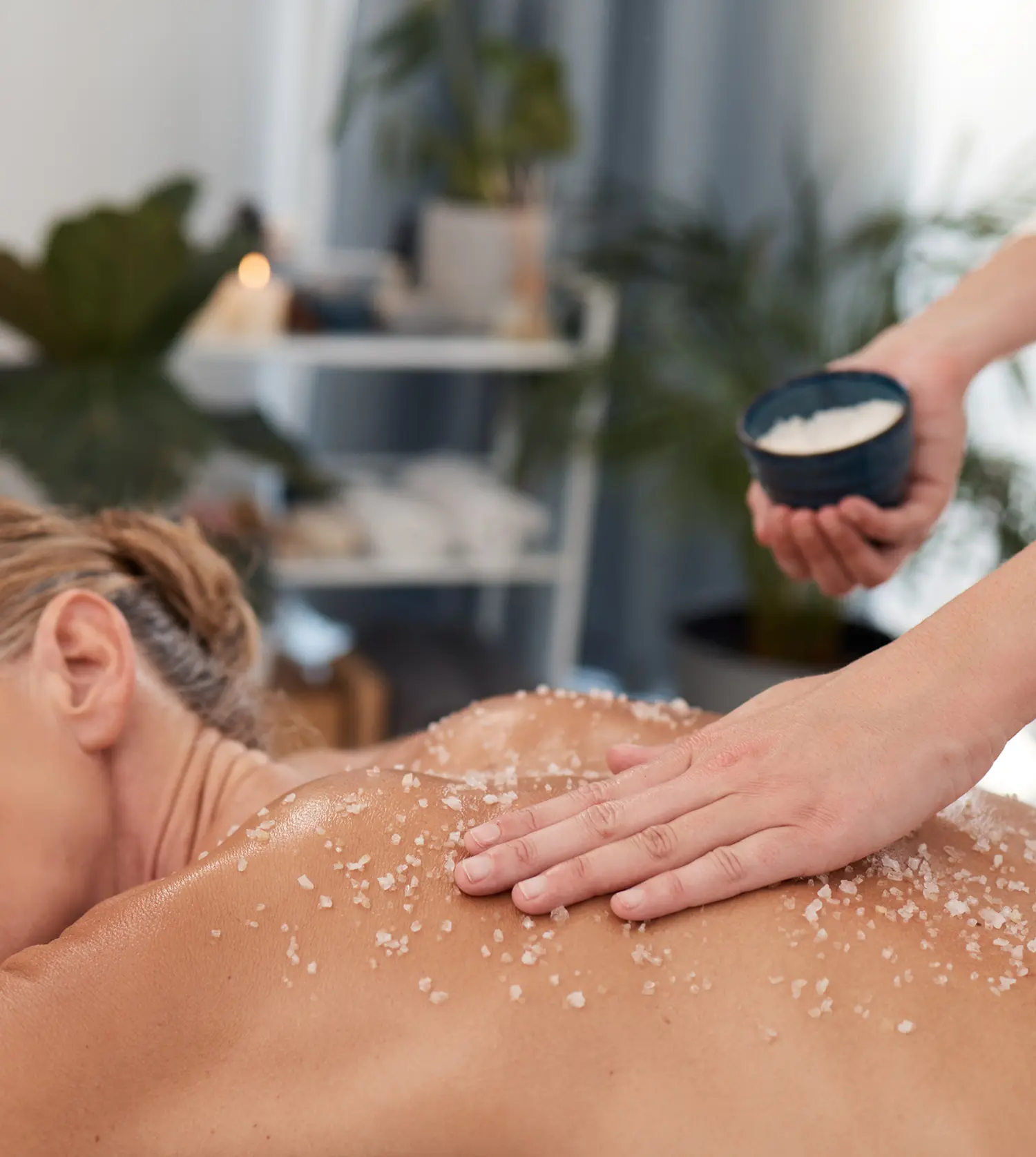 Woman enjoying a relaxing salt scrub on her back as part of the Transformation Journey spa package at Pause Spa