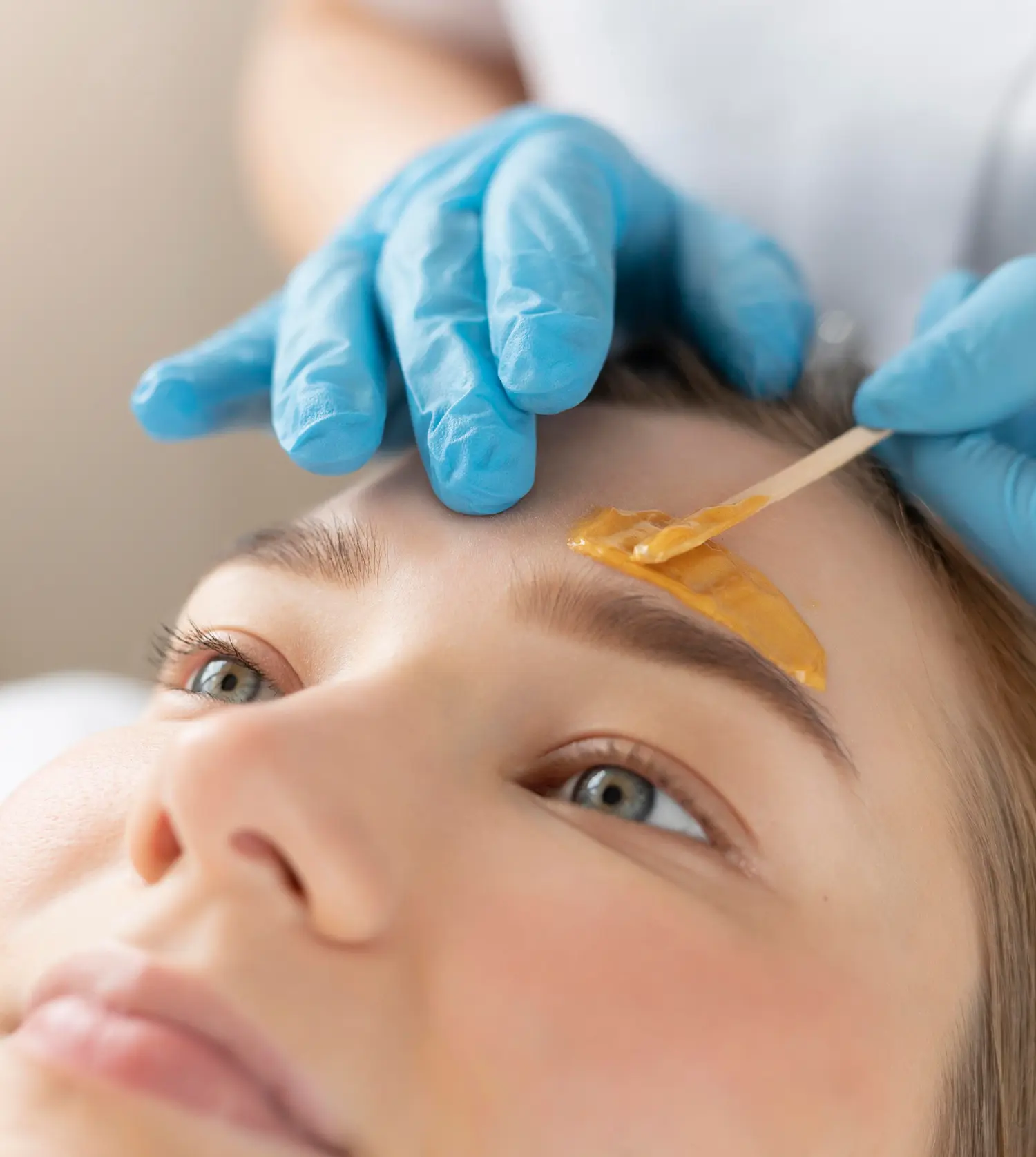Therapist shaping a client's eyebrows during her Brow Wax & Shape experience at Pause Spa