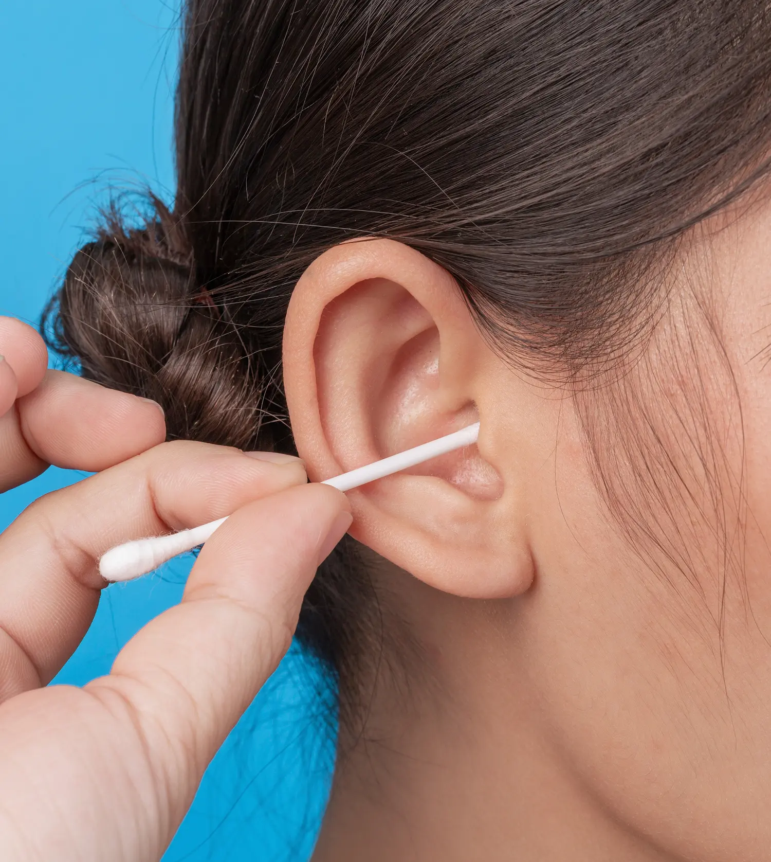 Woman with a q-tip placed inside her ear during her Nose/Ears Wax experience at Pause Spa